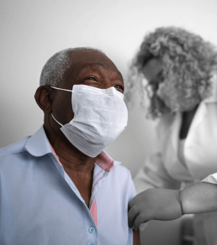 Man wearing mask being treated by doctor