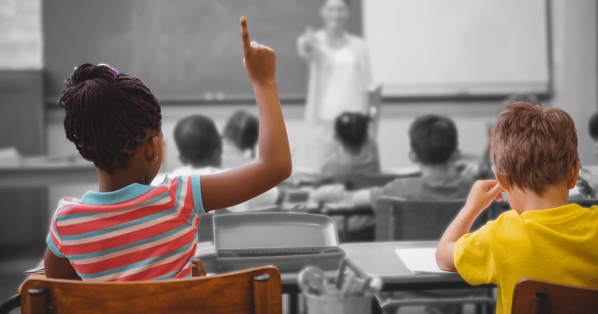 Child in class raising their hand